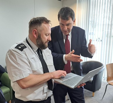 The minister is being given a demo of the DVPN app by Ch Insp Dan Tillett