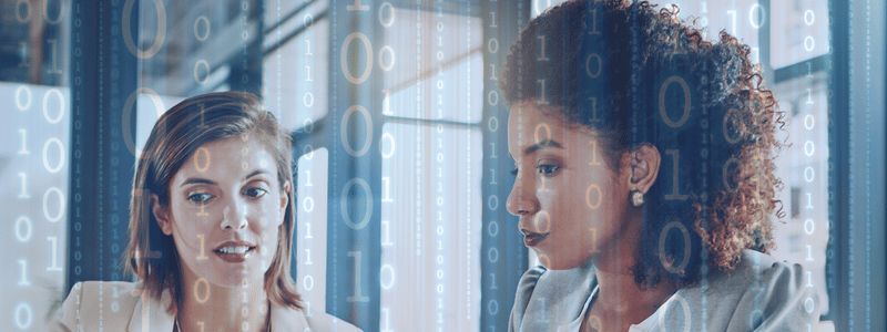Two women meeting, with a binary background in an office.